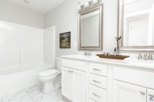 bathroom featuring double vanity, marble finish floor, toilet, and a sink