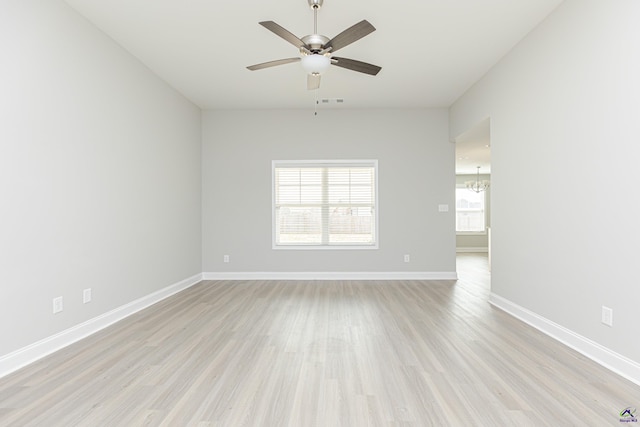 spare room with a healthy amount of sunlight, light wood-type flooring, and baseboards