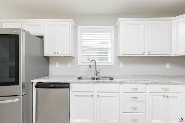 kitchen featuring backsplash, white cabinets, appliances with stainless steel finishes, and a sink