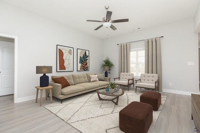 living area with baseboards, visible vents, light wood-type flooring, and ceiling fan