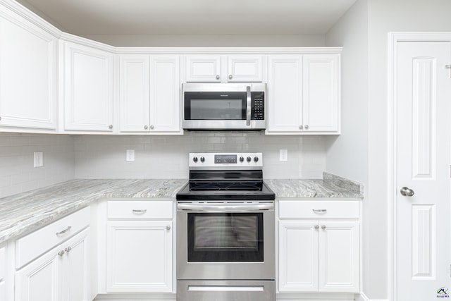 kitchen featuring light stone countertops, tasteful backsplash, appliances with stainless steel finishes, and white cabinets