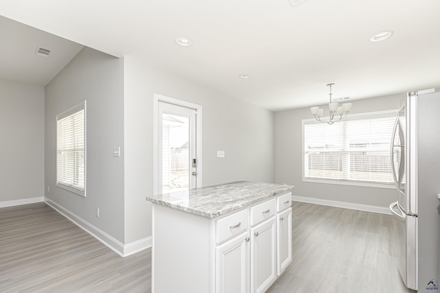 kitchen featuring a notable chandelier, visible vents, plenty of natural light, and freestanding refrigerator