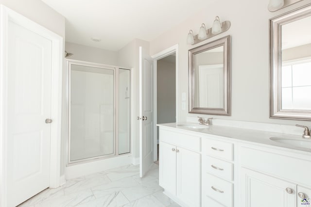 bathroom with a sink, marble finish floor, a shower stall, and double vanity