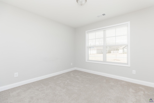 unfurnished room featuring visible vents, baseboards, and carpet