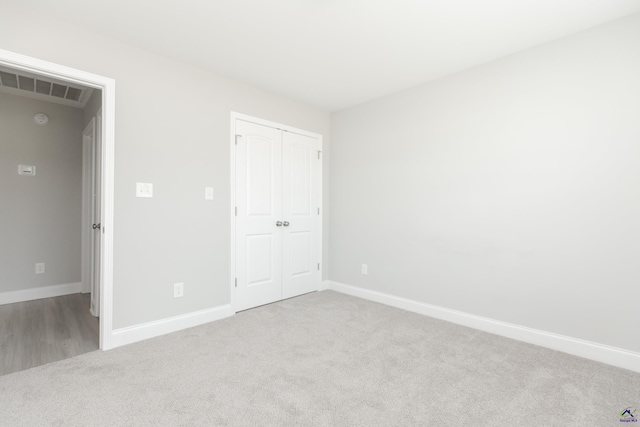 unfurnished bedroom with a closet, visible vents, baseboards, and carpet