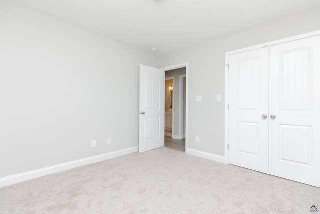 unfurnished bedroom with a closet, baseboards, and carpet floors