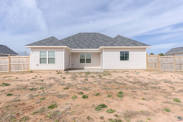 rear view of house with a fenced backyard and a patio area