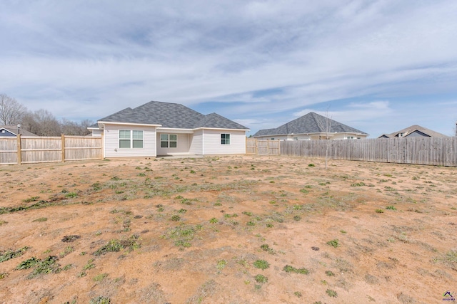 rear view of property featuring a fenced backyard