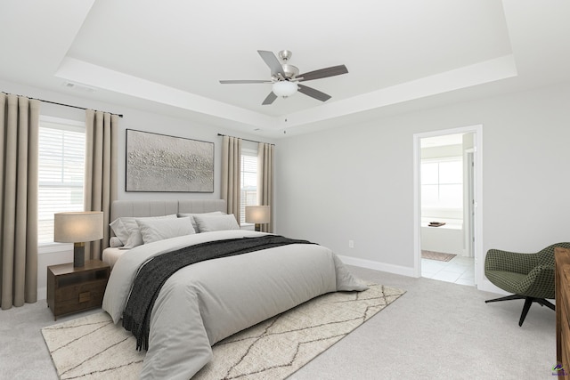 bedroom featuring visible vents, a raised ceiling, and light carpet