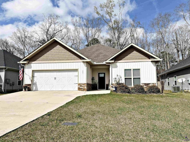 view of front of home featuring driveway, stone siding, board and batten siding, a front yard, and an attached garage