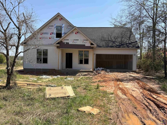 view of front of property with a garage, roof with shingles, and driveway