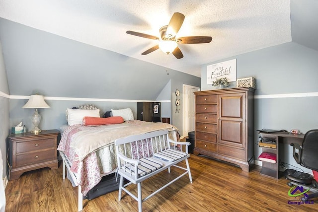 bedroom featuring vaulted ceiling, wood finished floors, an office area, ceiling fan, and a textured ceiling