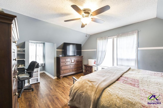 bedroom featuring vaulted ceiling, wood finished floors, a textured ceiling, baseboards, and ceiling fan