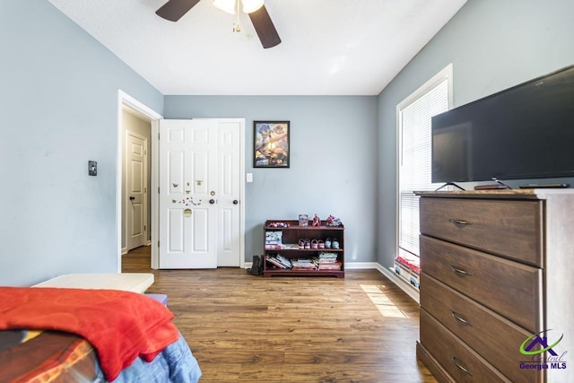 bedroom with wood finished floors, a ceiling fan, and baseboards