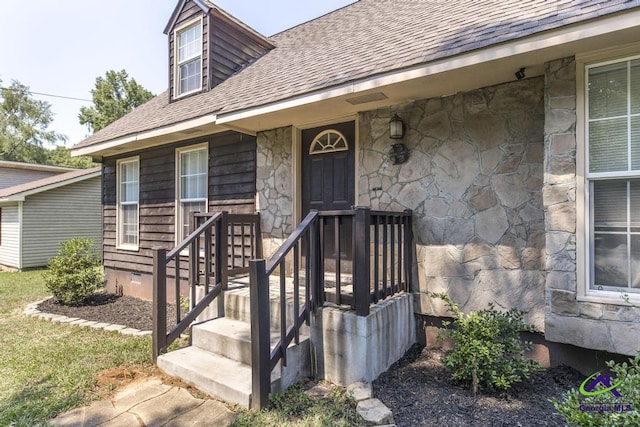view of exterior entry featuring stone siding and roof with shingles