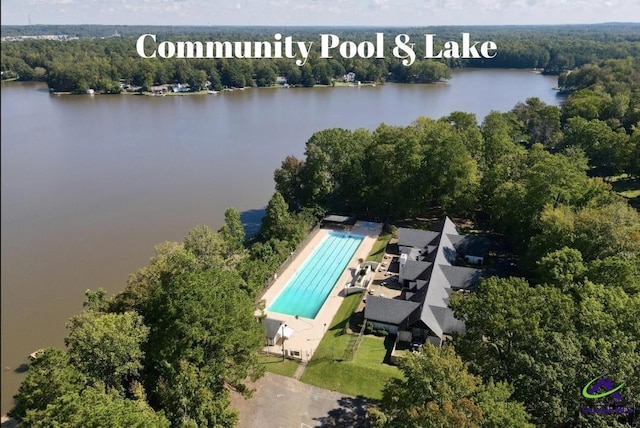 aerial view of property's location with a nearby body of water and a heavily wooded area