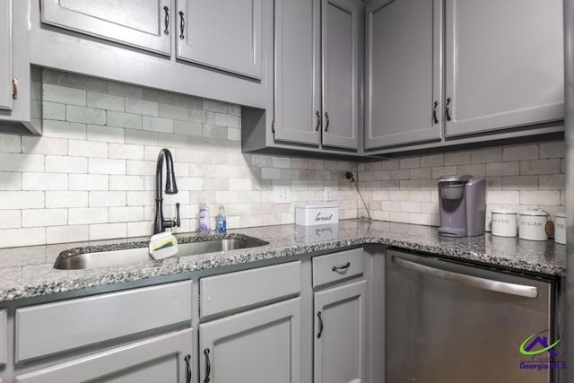 kitchen with dishwasher, a sink, gray cabinetry, and backsplash