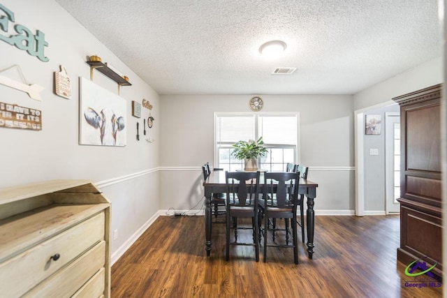 dining room with dark wood finished floors, baseboards, and a textured ceiling
