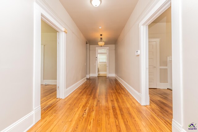 hallway with baseboards and light wood-style floors