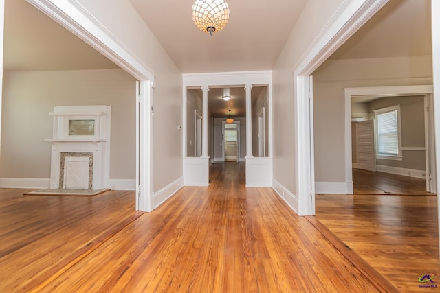 interior space featuring a fireplace, light wood-type flooring, and baseboards