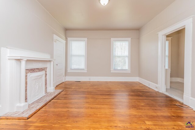 unfurnished living room featuring visible vents, a fireplace, and light wood finished floors