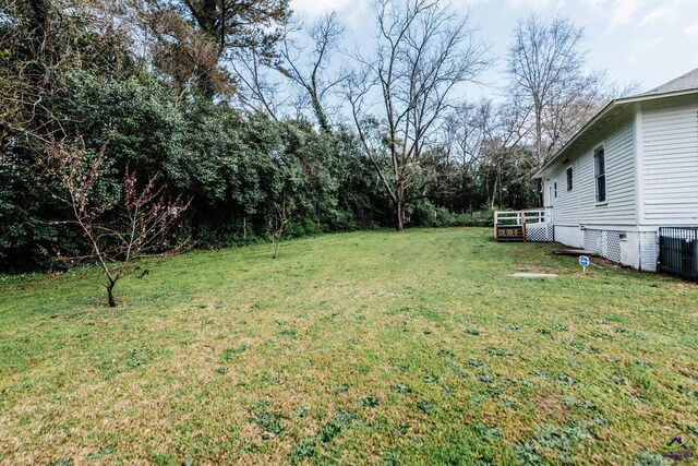 view of yard featuring central AC and a deck