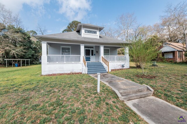 bungalow featuring covered porch and a front lawn