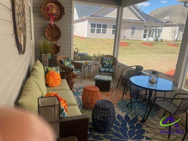 sunroom / solarium with a healthy amount of sunlight and an outdoor hangout area