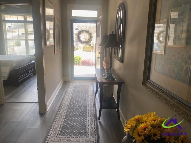 doorway with wood finished floors and baseboards