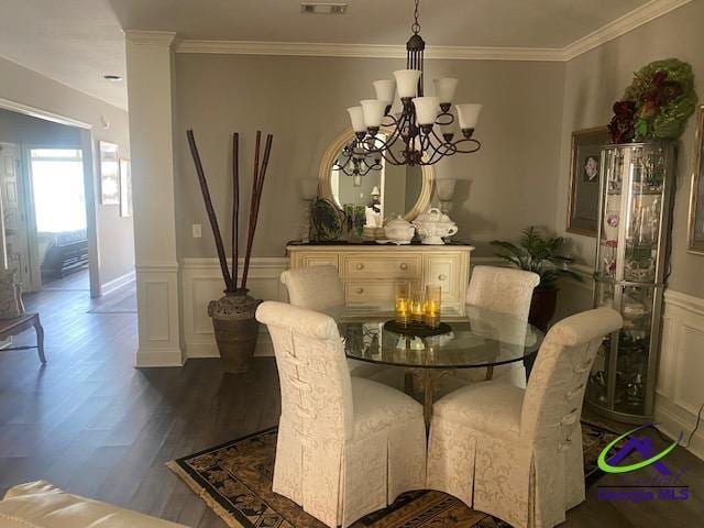 dining area featuring a wainscoted wall, an inviting chandelier, dark wood-style flooring, and crown molding