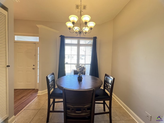 dining room with a notable chandelier, light tile patterned floors, baseboards, and visible vents