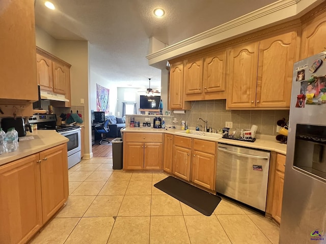 kitchen with a sink, under cabinet range hood, backsplash, stainless steel appliances, and light tile patterned flooring