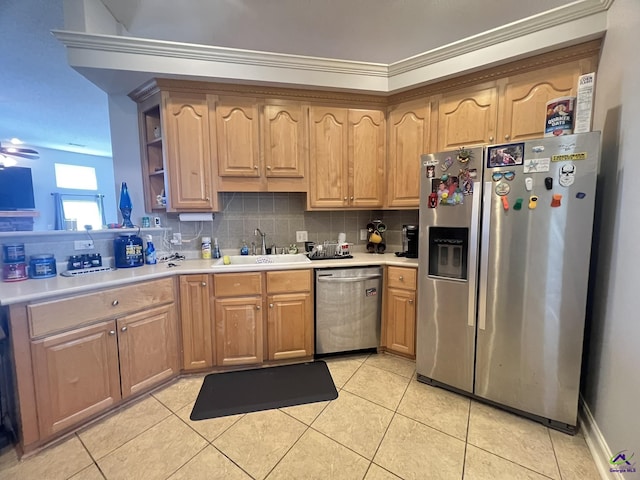 kitchen with light tile patterned floors, a sink, decorative backsplash, light countertops, and stainless steel appliances