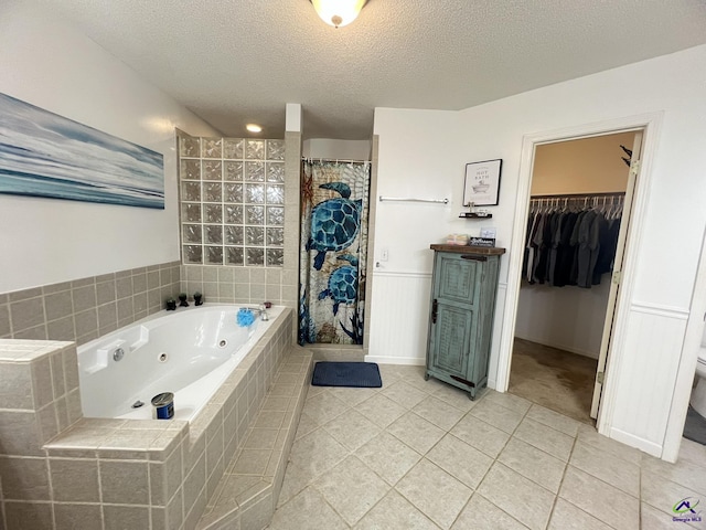 bathroom with curtained shower, a textured ceiling, wainscoting, tile patterned flooring, and a whirlpool tub