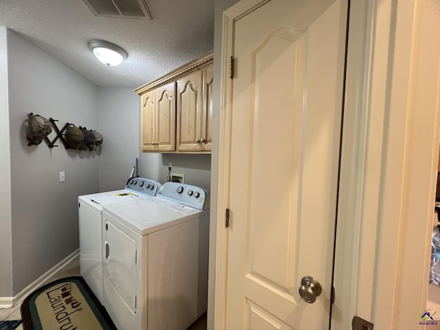 washroom with baseboards, visible vents, cabinet space, a textured ceiling, and washer and clothes dryer