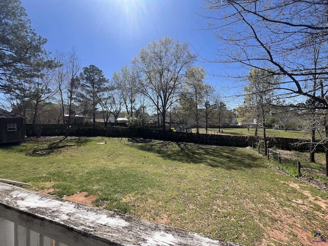 view of yard with an outbuilding, a shed, and a fenced backyard