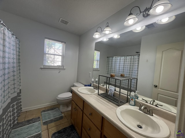 full bath with a sink, visible vents, toilet, and double vanity