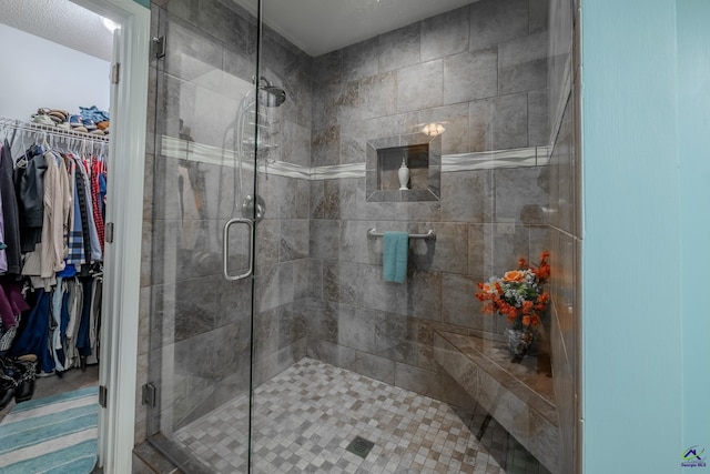 full bathroom featuring a spacious closet and a shower stall