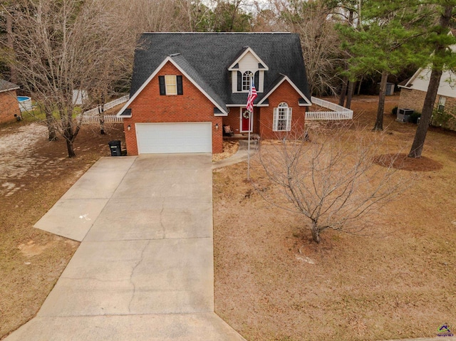 view of front facade with brick siding, driveway, and roof with shingles