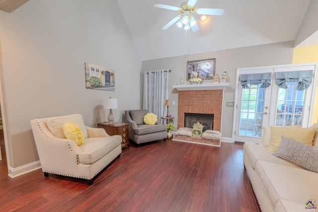 living room with dark wood-type flooring, high vaulted ceiling, a brick fireplace, and ceiling fan