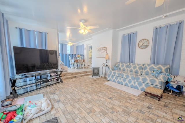 living room with a ceiling fan and brick floor