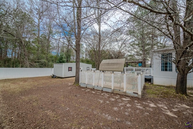 view of yard featuring an outbuilding, a deck, and fence