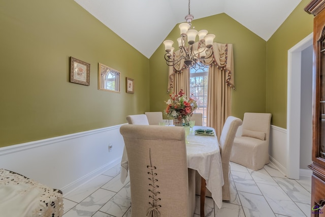 dining room featuring a wainscoted wall, lofted ceiling, a notable chandelier, and marble finish floor