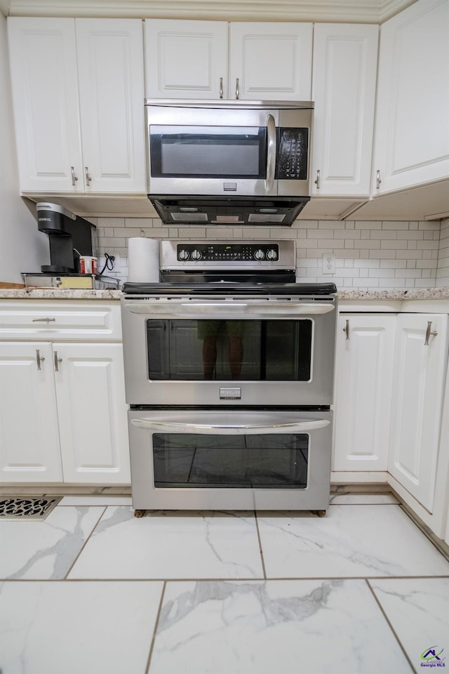 kitchen featuring marble finish floor, appliances with stainless steel finishes, and white cabinets