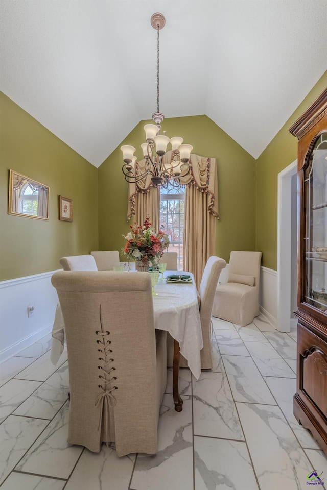 dining space featuring a wainscoted wall, marble finish floor, and a chandelier