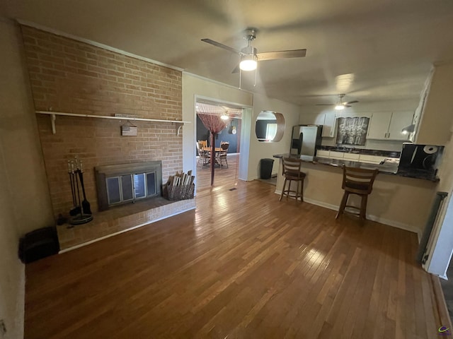 78 Duncan St, Fort Valley, GA 31030 - living room with hardwood / wood-style floors, a ceiling fan, and a brick fireplace