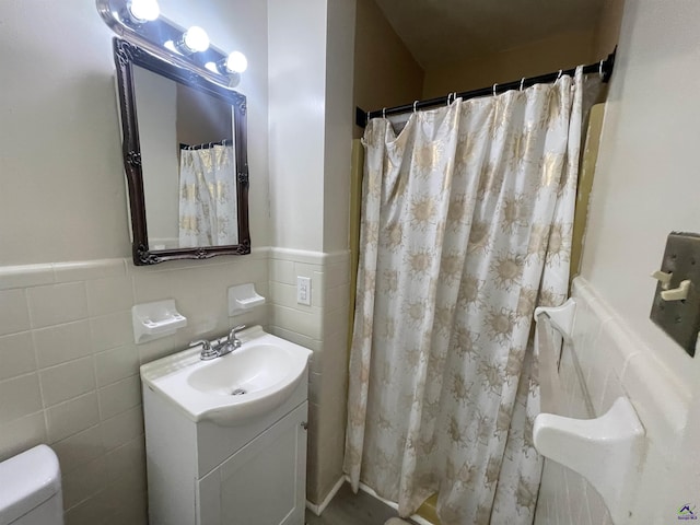 78 Duncan St, Fort Valley, GA 31030 - full bathroom with a wainscoted wall, vanity, tile walls, and a shower with shower curtain