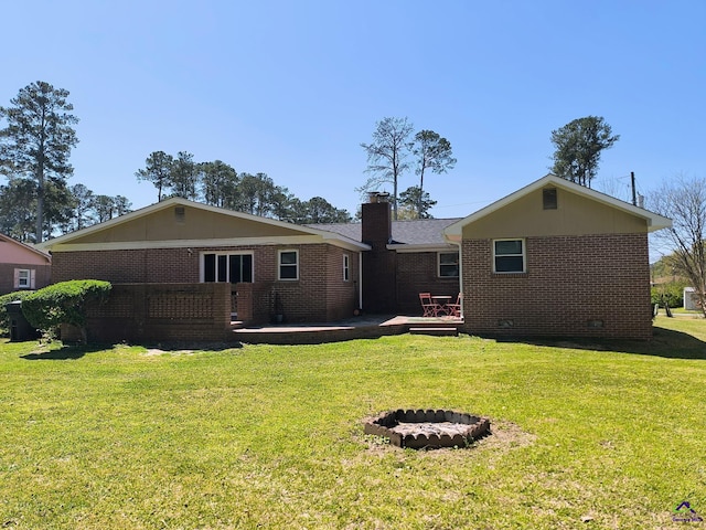 78 Duncan St, Fort Valley, GA 31030 - rear view of property with brick siding, a yard, a chimney, and a fire pit