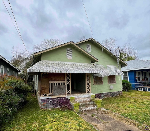 bungalow featuring a porch and a front lawn