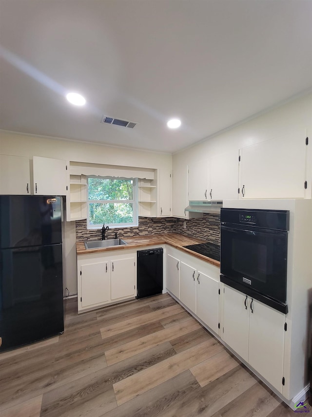 kitchen featuring white cabinets, visible vents, under cabinet range hood, a sink, and black appliances